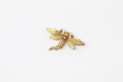 null Broche en or jaune 18k (750) stylisant une libellule ornée de pierres rouges.

Poids...