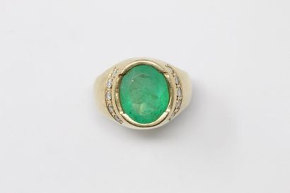 null 18K (750) yellow gold signet ring set with an oval emerald between two lines...
