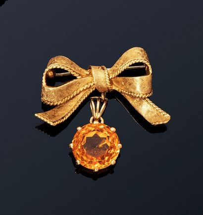 null 18K (750) yellow gold brooch stylizing a bow of guilloche ribbon holding a round...