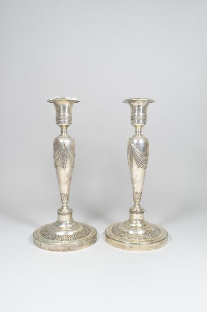 null Pair of torches and two silver bobèches, the round base chiselled with a frieze...