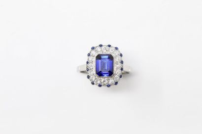 null Platinum ring adorned with a rectangular imitation blue stone with sides, surrounded...
