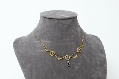 null Collier « draperie » en or jaune 18K (750) orné de trois motifs ronds ciselés,...