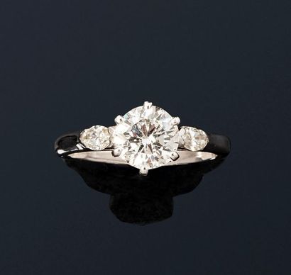 null 18K (750) white gold ring set with one brilliant-cut diamond, the shoulder set...