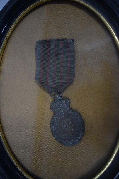 null Médaille de Sainte Hélène en bronze patiné, avec son ruban (usure). 

Présentée...