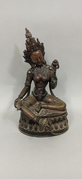 null TIBET - Vers 1900

Statuette de tara en bronze à patine brune, assise le pied...