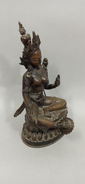 TIBET - Vers 1900 
Statuette de tara en bronze à patine brune, assise le pied posé...