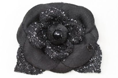 CHANEL CHANEL 

Broche en tissu noir stylisant une fleur. Le logo chanel sur l'un...