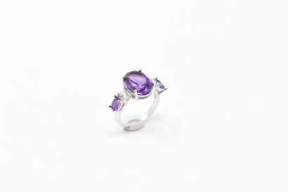 null Silver ring set with an oval amethyst supported by a round white stone and an...