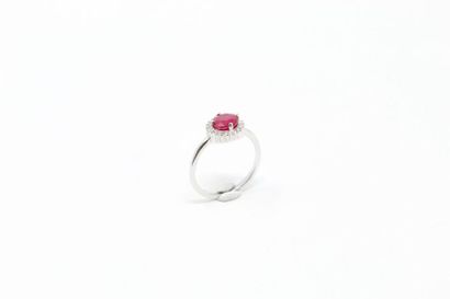 null Silver ring decorated with a round ruby in a white stone surround. 

Finger...