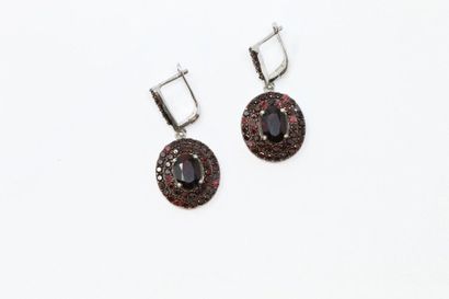 null Pair of silver earrings decorated with oval and round garnets.

(Missing) 

Gross...