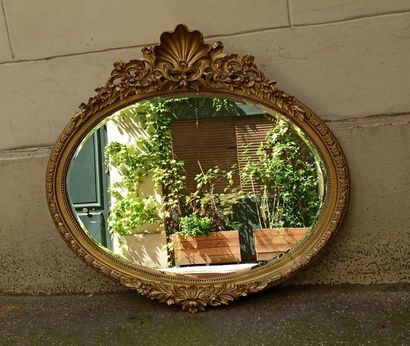 null Oval wooden and stucco carved and gilded mirror with beaded frieze, laurel leaf...