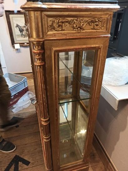 null A cabinet at the height of support forming a gilded stuccoed wooden showcase...