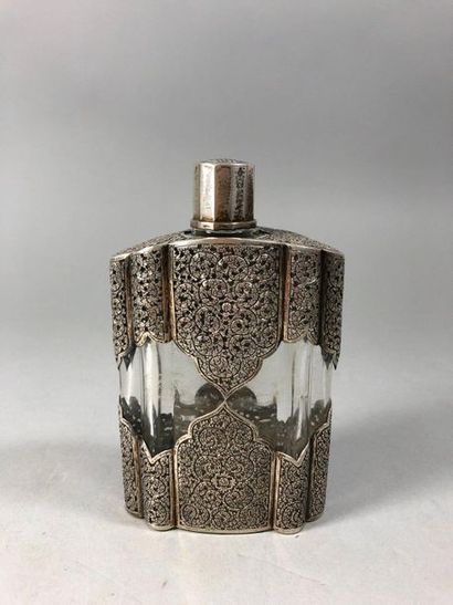 null Poly-lobed glass bottle decorated with a chased and openwork silver trim with...