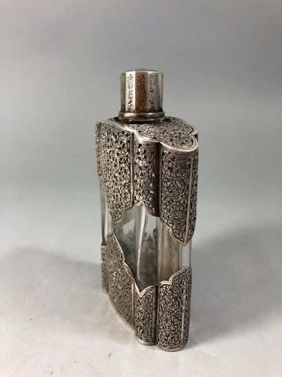 null Poly-lobed glass bottle decorated with a chased and openwork silver trim with...