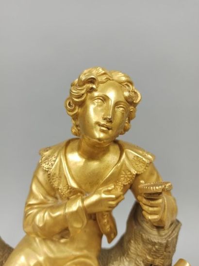 null Clock in gilt bronze representing a young man looking at a miniature of a young...