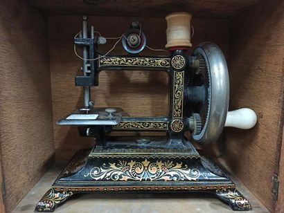null Sewing machine in black lacquered metal with painted gold leaf frieze decoration,...