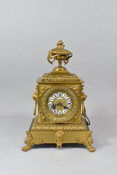 null Carved and gilded bronze mantel clock resting on four claw feet and surmounted...