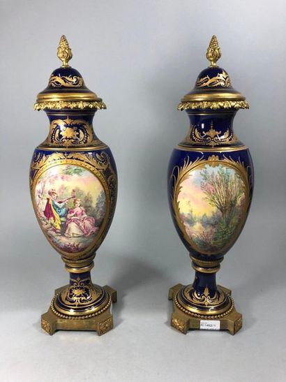 null Paire de vases en porcelaire dans le goût de Sèvres, à fond bleu, décor de scène...