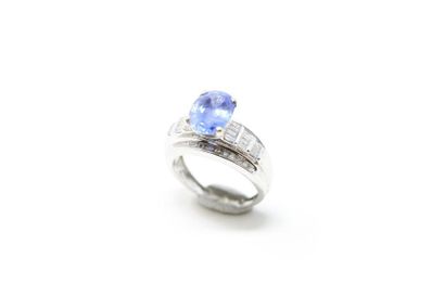 null 9K (375) white gold ring set with an oval sapphire shouldered with baguette...