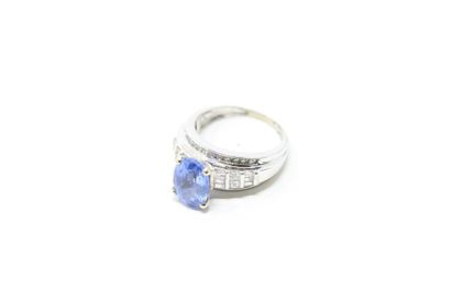 null 9K (375) white gold ring set with an oval sapphire shouldered with baguette...