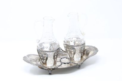 null Oval silver oil tank and two cut crystal flasks; standing on four legs, the...