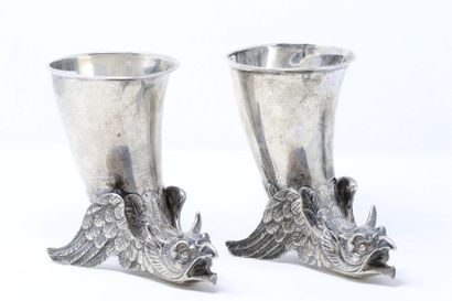 null Two silver cups in the shape of a rhyton, the base resting on a winged griffin....