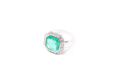 null Platinum ring set with an octagonal emerald in a frame of twenty brilliants....