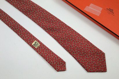 HERMES HERMES

Cravate en soie, à motifs de mors (7580 SA) sur fond rouge brique....
