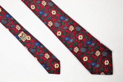 HERMES HERMES 

Cravate en soie à motifs floraux et feuillagés sur fond bordeaux....