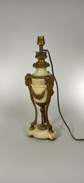 null Alabaster lamp with bronze ornamentation resting on three columns decorated...