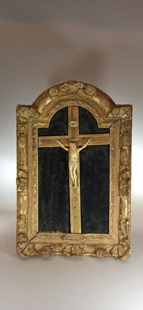 null An ivory cross Christ in a gilded wood and stucco frame with stylized flower...
