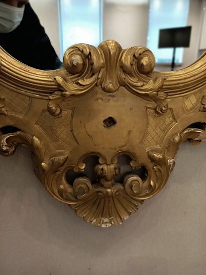 null Carved and gilded wood mirror with a moving shape and a mascaron decoration...