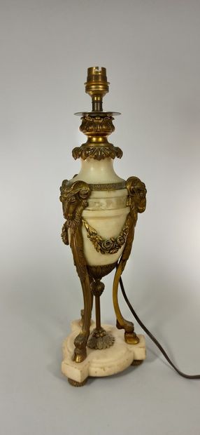null Alabaster lamp with bronze ornamentation resting on three columns decorated...