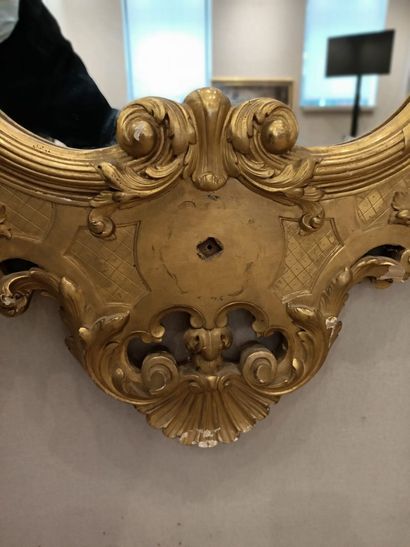 null Miroir en bois sculpté et doré de forme mouvementé à décor d'un mascaron centré...