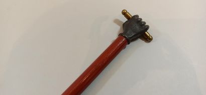  Cane, pommel decorated with a closed hand holding a stick, 
Length: 84 cm