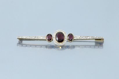 null An 18K (750) yellow gold and platinum barrette brooch centered on an oval pyrope-almandine...