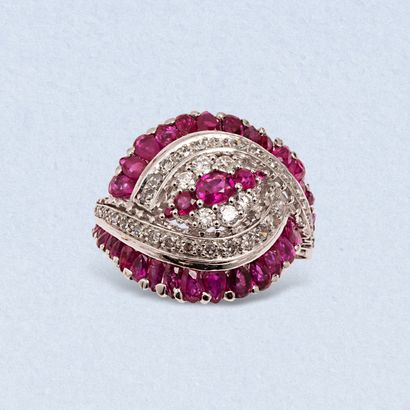 null An 18K (750) white gold "cocktail" ring centered on a line of round rubies falling...