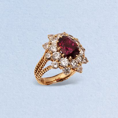  18K (750) yellow gold twisted triple-ring daisy ring, centered on an oval ruby in...