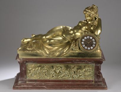 null Odalisque clock resting on a high red marble base decorated with bronze reliefs...