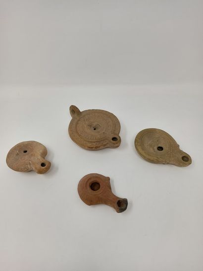 null Set of four oil lamps, one with a double scroll nozzle representing a bear and...