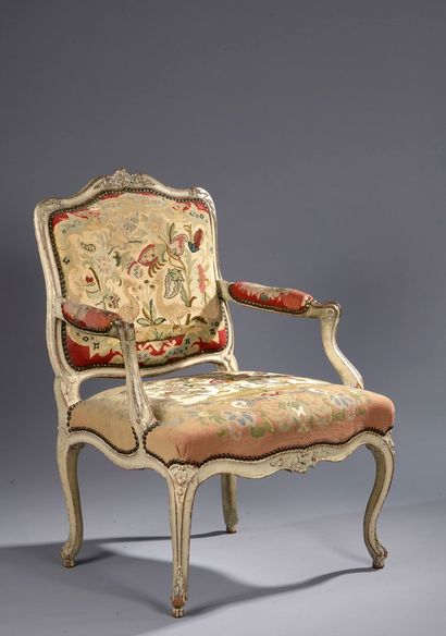 null A carved, moulded and grey lacquered beechwood armchair, decorated with flowers...