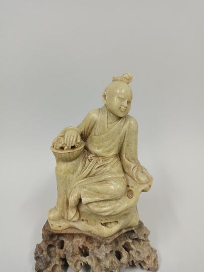 null CHINA - 20th century

A steatite group of a child sitting on a rock with a flowery...