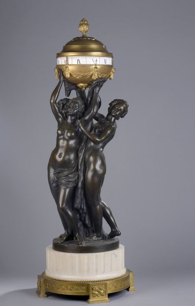 null Clock with the three Graces resting on an ormolu base decorated with a frieze...