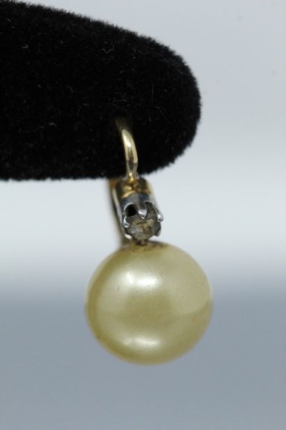 null Paire de dormeuses en or jaune 18k (750) une perle baroque sertie, épaulée par...