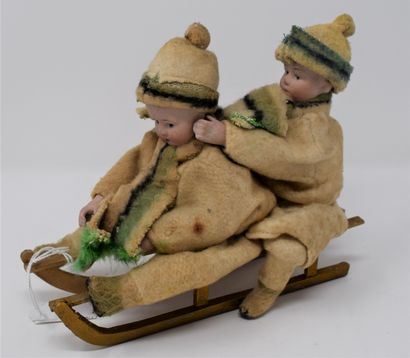 null Two children on a sledge, heads and hands in biscuit.

L. : 18 cm.