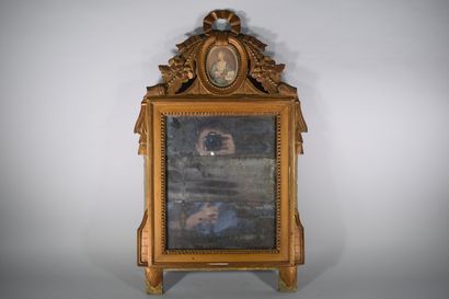 null Mercury mirror mounted in a gilded and carved wooden frame decorated with an...