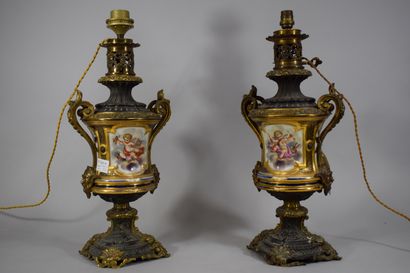 null A pair of polychrome porcelain oil lamps decorated with a bust of a woman on...