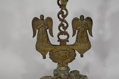 null Bronze crucifix, two angels and a lamb at its base, it rests on a tripod support...