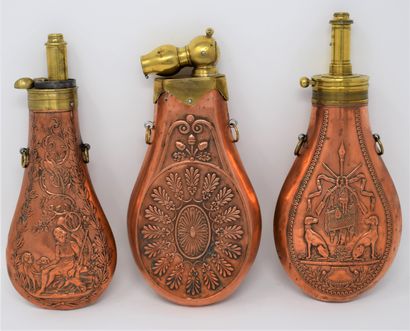 null Three brass and copper powder flasks with cygetic decoration, with two rings...