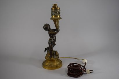 null Bronze lamp representing a putto, a cymbal at its feet, round fluted base decorated...